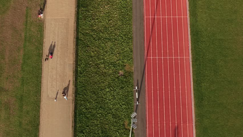 Aerial view looking down over sporting preparation on red athletics running track at Parliament hill