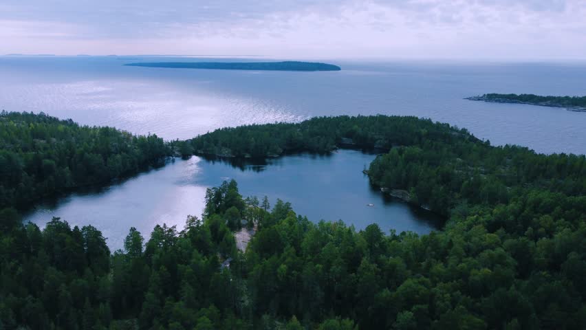 Russia, Lake Ladoga, Koyonsaari. View of the coast of the island in a cold lake. Beautiful nature of the Republic of Karelia. Panoramic view from the height of the Ladoga skerry islands. 4K