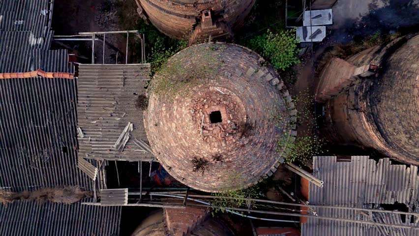 Traditional dome shaped brick making Kiln factory by canal on Mekong Delta. Drone birds eye lift, Vinh Long, Vietnam.