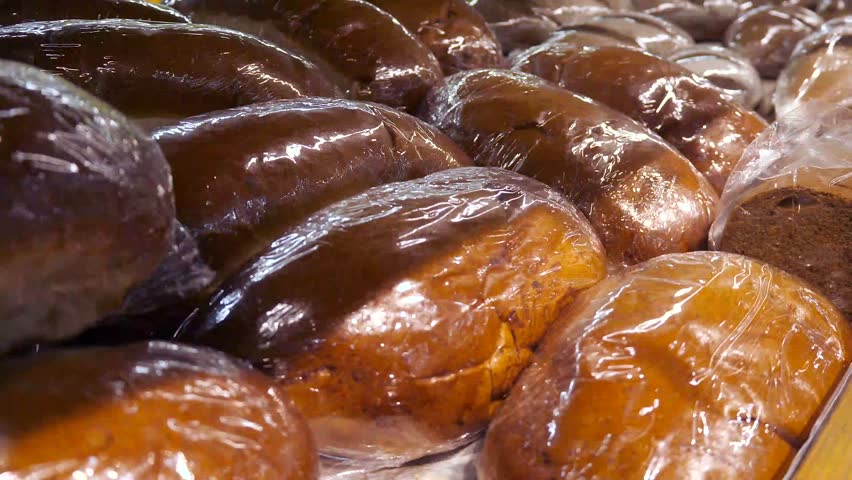 Large quantities of baked goods (loaf or bread) in transparent cellophane bags. Bakery products with a long shelf life.