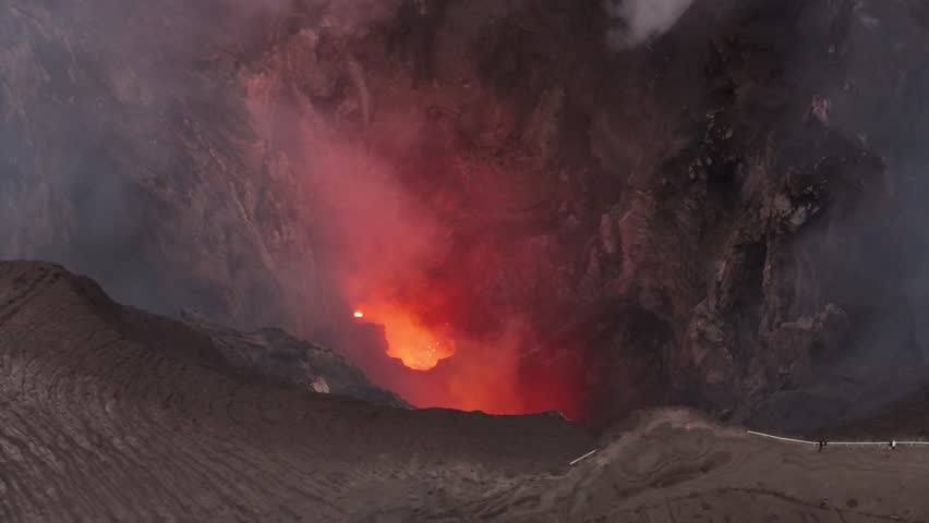 People watching small eruption from volcano crater rim in Tanna Island, Vanuatu. Drone