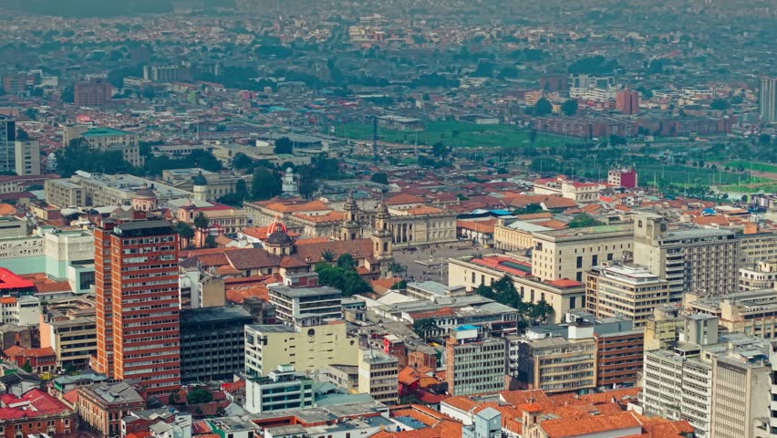 Aerial orbit establishing 70mm telephoto establishing of the architectural contrast of the Candelaria area, Colombia National Capitol, Plaza de Bolivar on a sunny day, Bogota, Colombia.