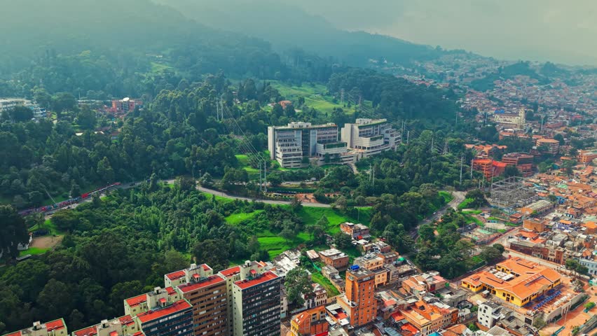 Aerial view establishing the Universidad Externado on a hillside of Monserrate hill on a cloudy day, hillside with lots of greenery. Bogota, Colombia