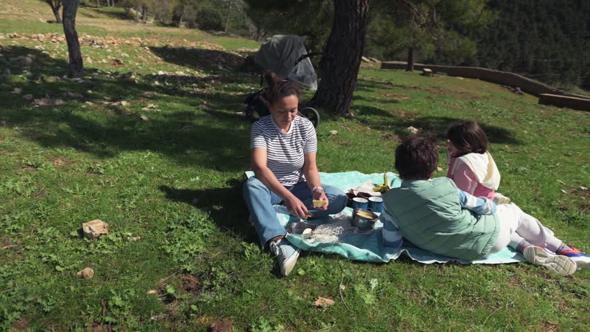 Family Picnic in Nature: Mother and Kids Enjoying Quality Time Outdoors