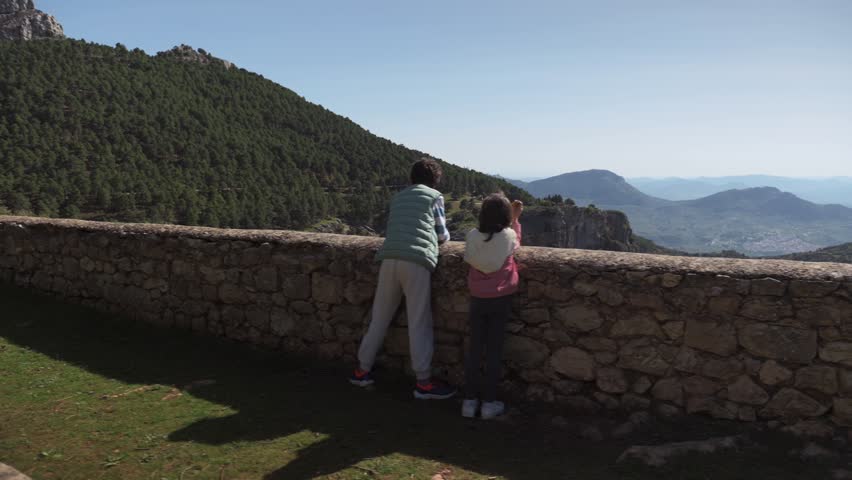 Mountaintop Picnic: Children Enjoying Snacks and Drinks with a Stunning View