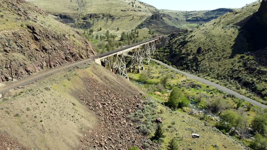 US, Oregon, Madras, Trout Creek, 2025-04-19 - Drone view of a steel train trestle bridge over the creek in the springtime in central Oregon.