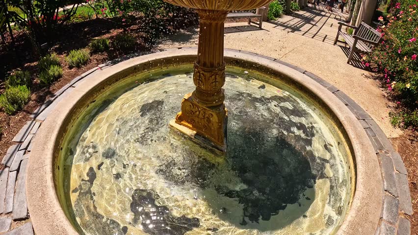 footage of a water fountain with lush green trees and colorful flowers at Huntington Library and Botanical Gardens in San Marino California USA