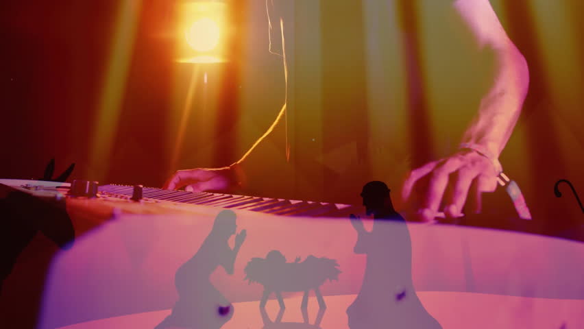 musician playing electronic keyboard on concert stage, with animated nativity silhouettes glowing. Performance, entertainment, vibrant, atmospheric, theatrical, multimedia, concert