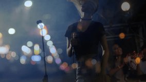 Female singer holding mic, performing music under lights, city bokeh behind, sound bars rising. Live music, performance, night, urban, concert, stage, entertainment - Powered by Shutterstock - Get 15% off with code: PIKWIZARD15
