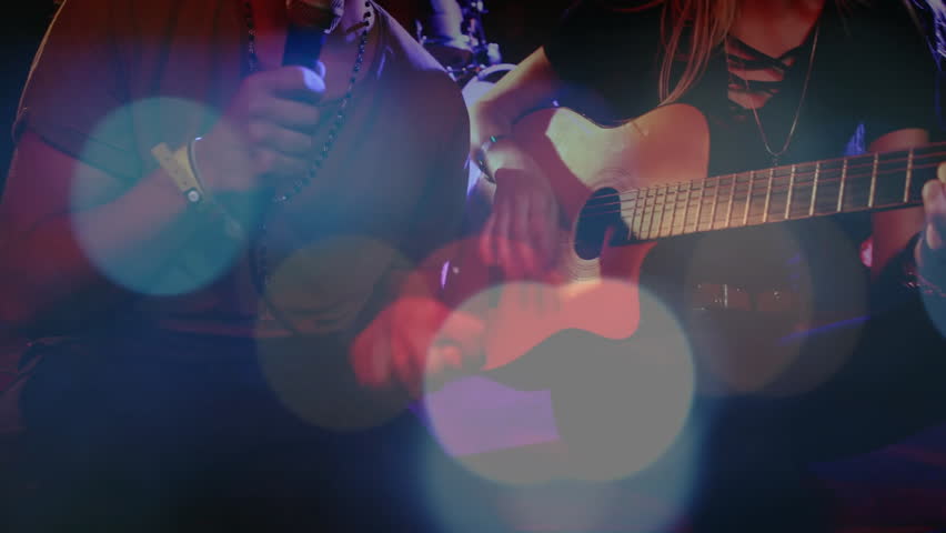 Performing duo singing and playing guitar on stage, featuring animated music note and wave overlays. Music, performance, talent, concert, nightlife, entertainment, atmosphere