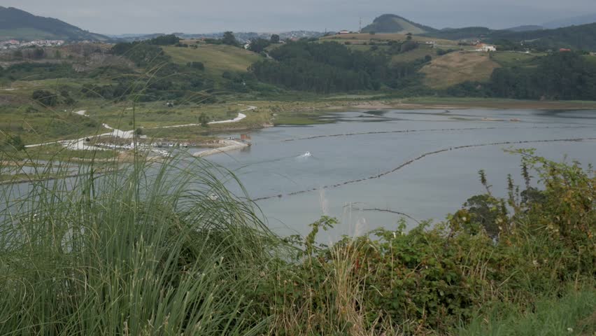 Peaceful view of Ría San Martín, Suances, with green hills and calm water
