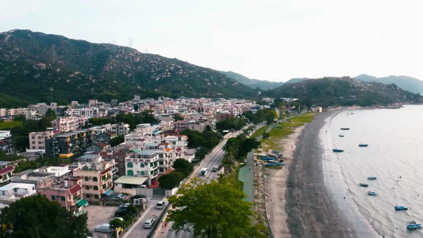 Aerial View of Coastal Town with Beach and Mountains