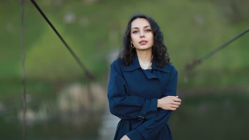 Portrait of a beautiful Asian woman with long black hair and wearing blue coat.