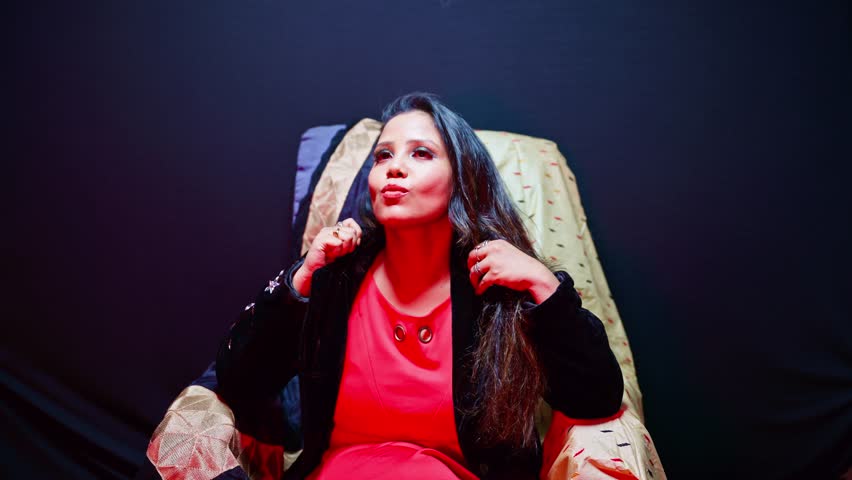 Woman Smiling as Posing Under Colorful Light, Girl Sitting and Modeling in Photo Studio, Female posturing Creating Portfolio at Workspace, Elegant Lady on Chair portraying for Movie shoot, Profession