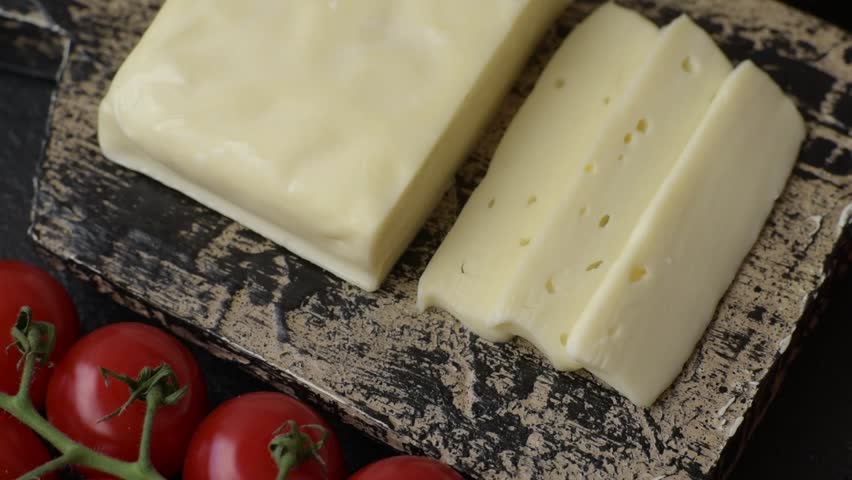 Dairy white mozzarella cheese sliced as an ingredient for caprese salad with tomatoes