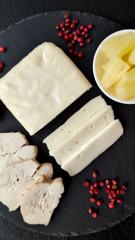 Dairy white mozzarella cheese sliced as an ingredient for caprese salad with tomatoes