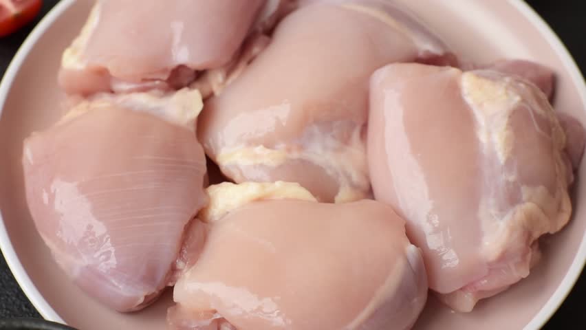 Chicken thigh fillet raw, skinless, boneless, poultry legs with salt and spices