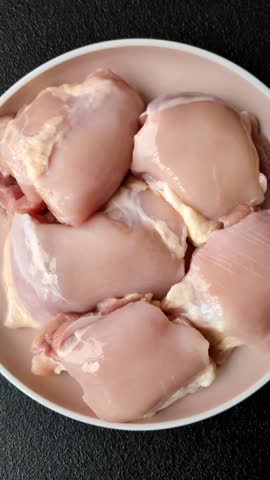 Chicken thigh fillet raw, skinless, boneless, poultry legs with salt and spices