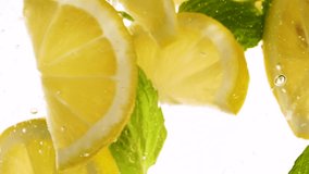 Slow motion slices of lemon or orange fruit and mint leaves splashing in water. HD footage - Powered by Shutterstock - Get 15% off with code: PIKWIZARD15