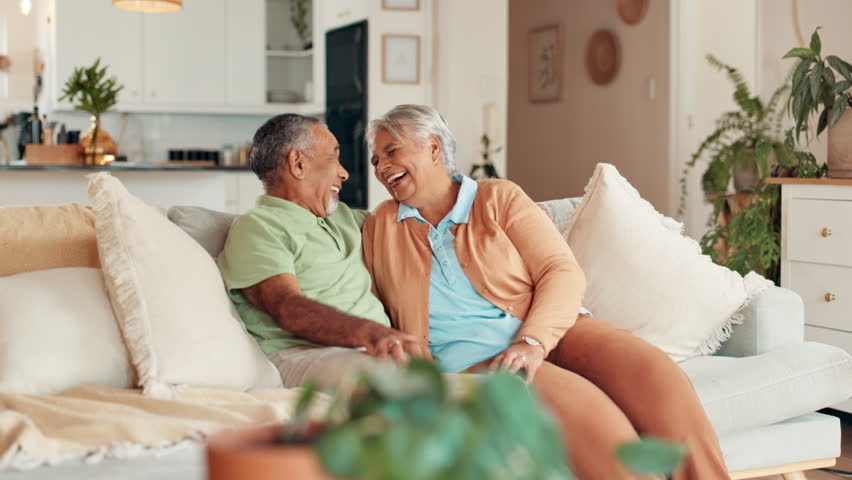 Senior, couple and laughing on sofa in retirement for funny conversation, comic story and bonding together. Happy, elderly people and relax in home with discussion, relationship and trust with love
