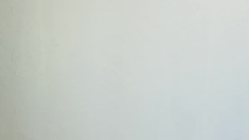 Snapping fingers. A woman's hand snapping her fingers against a white wall. HD video footage