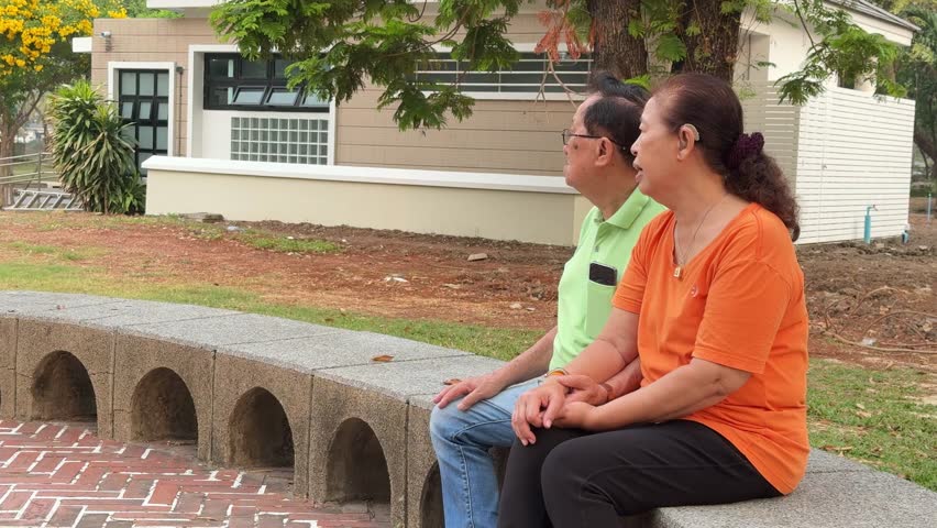 The East Asian senior couple is spending time together in the park.