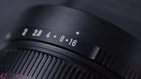 Closeup: Aperture ring changing on camera old Lens, adjusting F-Stop number and iris, showing aperture scale and ring shifting. Professional photographer adjusting lens aperture stop. Close up shot - Powered by Shutterstock - Get 15% off with code: PIKWIZARD15