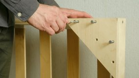 Hands man tightening bolts on simple wooden bed frame using hex key, showcasing DIY home assembly and hands-on furniture building skills. Diy concept at home. Moment of capturing ease use of diy. - Powered by Shutterstock - Get 15% off with code: PIKWIZARD15