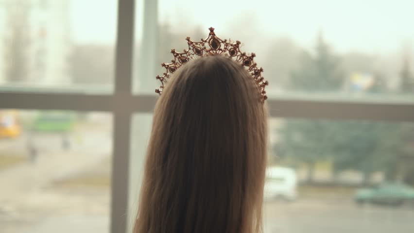 portrait close up fantasy beauty girl princess in golden crown on head. Medieval vintage dress. Cute young face. Historical woman glamorous queen. Fashion model look at window studio background