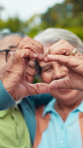 Heart, hands and senior couple with love, support or connection together outdoor. Closeup, man and woman with romantic symbol for marriage, care or commitment to relationship with loyalty to soulmate