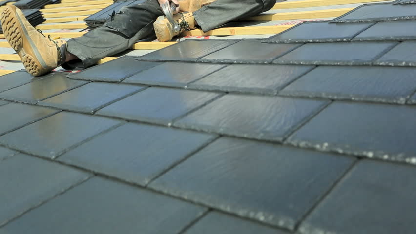 Construction worker installing slate tiles on new property roof, skilled tradesman roofer, building new home roof development Royalty-Free Stock Footage #3780287