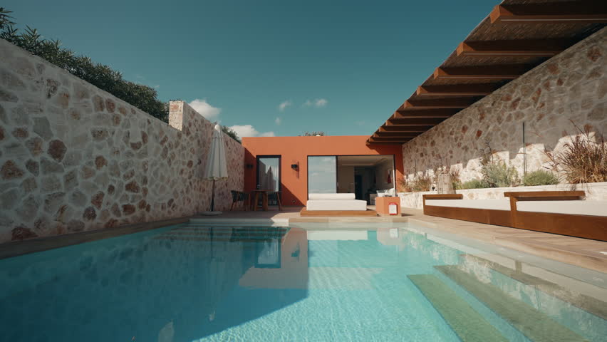 Wide Shot of Luxury Villa with Pool and Sunbeds in Beautiful Outdoor Setting