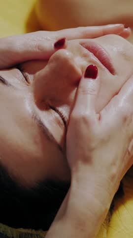 Anti-aging procedure, facial massage. close-up. woman is lying on couch and getting facial massage for toning up muscles and facial skin lymphatic drainage, at beauty clinic. Skin care, cosmetology. c