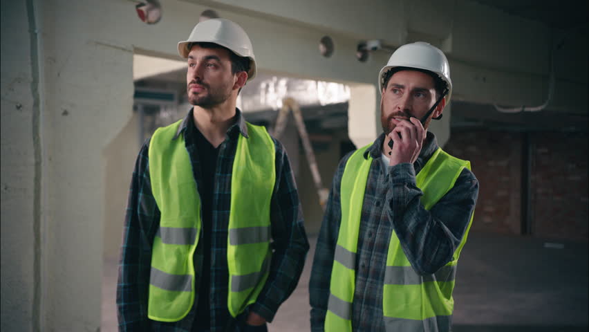 Caucasian men electricians builders guys architects males try speak walkie talkie broken device fail problem handymen foremen show new radio set tech mechanics communicate in construction manufacture