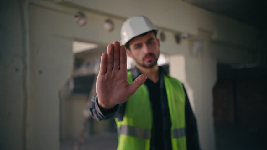 Serious dissatisfied Caucasian man showing hand gesture stop deny no build male guy builder reject not forbidden keep distance refusal sign worker repairman architect construction engineer contractor
