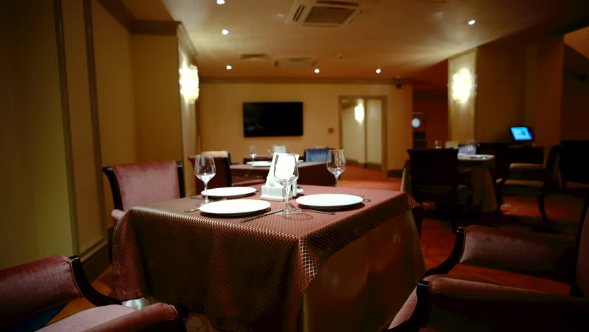 Elegantly made empty dinner tables in a chic restaurant shot with a slider