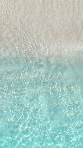 Top view of tropical beach with white sand and clear blue ocean turquoise water in natural sunlight, minimalist peaceful scenery background, relaxation, hotel, summer escape, Maldives island vacation
