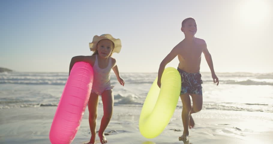 Running, inflatable and holiday with children at beach for travel destination, family vacation and freedom. Summer, playful and energy with kid siblings and swimming float for adventure and happiness