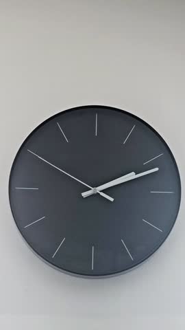 Timelapse of a black analogue clock for over an hour with silver ticking second and minute hands