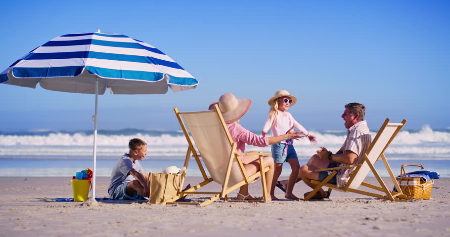 Family, excited and children at ocean with hug, bonding and happiness on summer vacation. Parents, kids and embrace at beach umbrella for love, support and appreciation for travel to California
