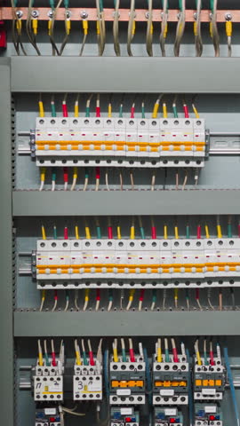 Rows of breakers and colorful wires on open circuit board. Switchboard with tools for automatic interruption of electrical current short circuit flow at station