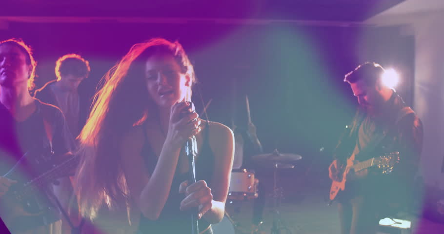 Band performing on music industry stage, with mic and guitar and floating sound wave graphics. Music, performance, entertainment, stage, concert, lighting, artistry