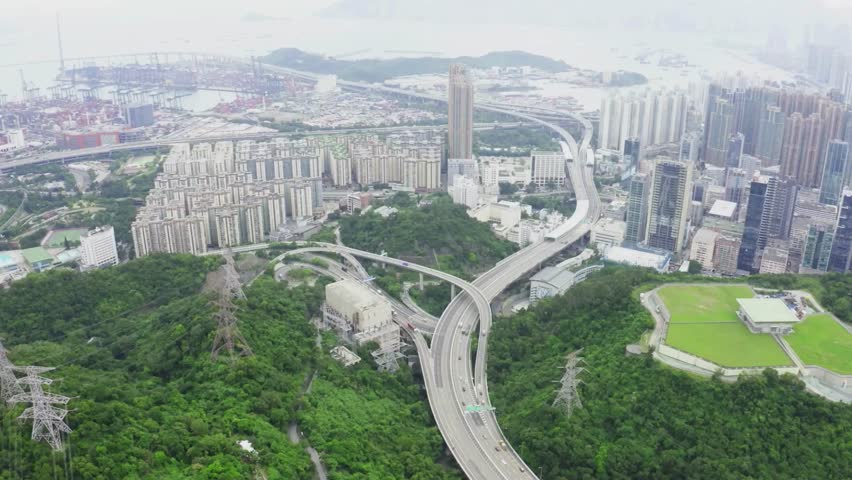 Aerial View of Hong Kong Cityscape with Elevated Roads and Lush Green Hills