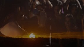 Female singer singing into microphone on stage with fans, showing sunset horizon for music industry. Entertainment, performance, atmosphere, energy, stage, concert, celebration - Powered by Shutterstock - Get 15% off with code: PIKWIZARD15