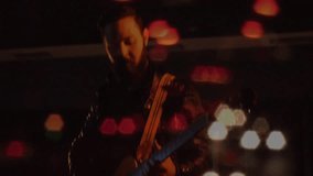 Bandmates playing electric guitar and bass on dim music stage, overlaying animated soundwave icons. Performance, concert, entertainment, nightlife, ambiance, creative, dynamic - Powered by Shutterstock - Get 15% off with code: PIKWIZARD15