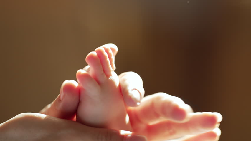 Infant baby foot massage. Parenting, wellness, early childhood. Nurturing touch