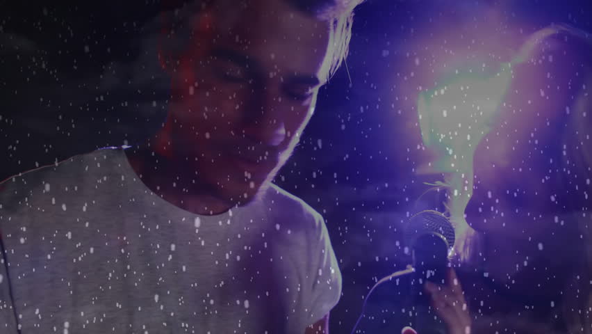 Male performer and female vocalist singing music duet on stage, showing floating confetti effect. Performance, duo, concert, stage, lighting, atmosphere, entertainment