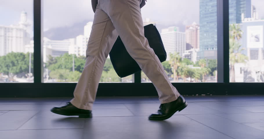 Office building, window and businessman walking with legs for corporate, career and job in morning. Attorney, feet and travel with bag in law firm lobby for professional, work and start of legal case