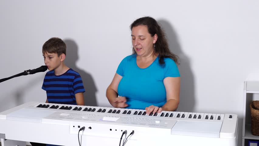 10 years old boy is sings the song and learns to play piano