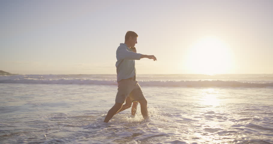 Beach, playful splash and couple for romance, honeymoon and travel for fun, kick and love. Woman, man and sea for date to show partner sunset, adventure or happy bonding and joy on Miami holiday